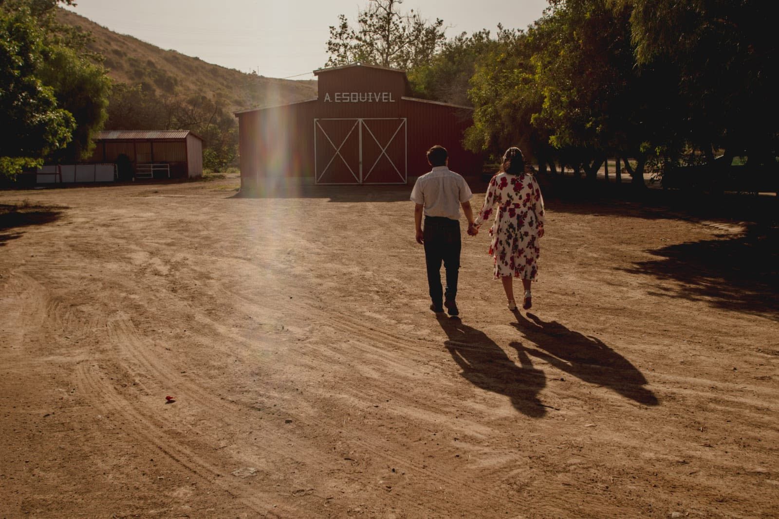 Pareja caminando hacia el granero rojo del Rancho 4 Milpas en el Cañón Rosarito